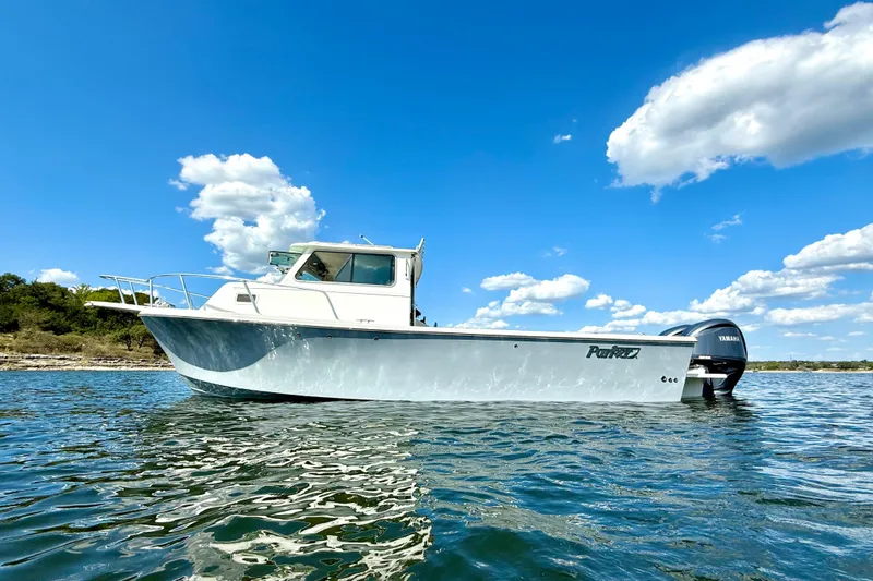 Slide: The Image of 2023 Parker 2820 XLD Sport Cabin boat on water under blue sky. - 4