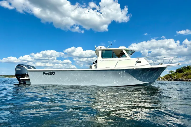 Slide: The Image of 2023 Parker 2820 XLD Sport Cabin boat on water under blue sky. - 7