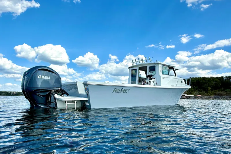 Slide: The Image of 2023 Parker 2820 XLD Sport Cabin boat on water, Yamaha engine, under blue sky. - 9