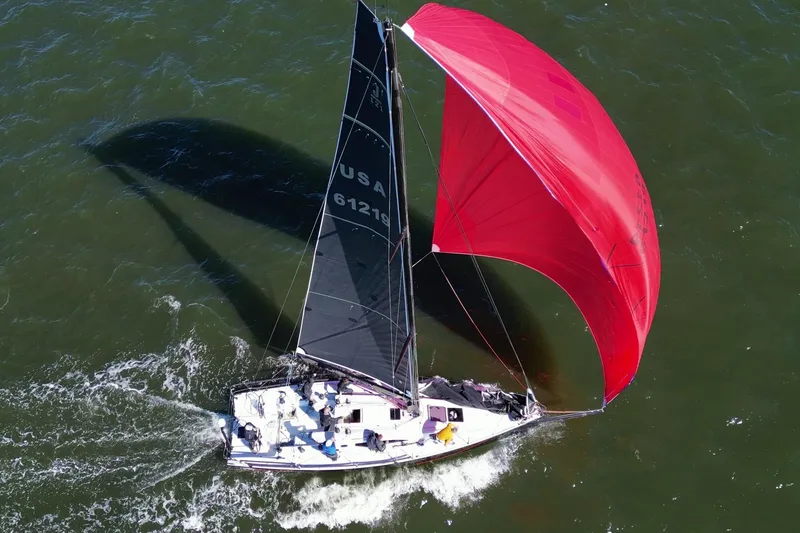 Slide: The Image of 2019 J Boats J 121 sailing with red spinnaker on open water. - 10