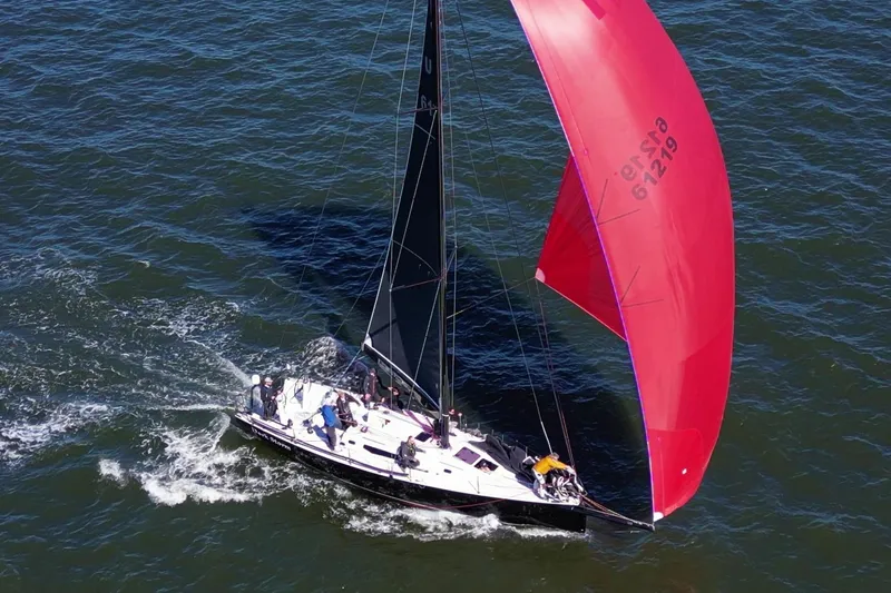 Slide: The Image of 2019 J Boats J 121 sailing with a vibrant red spinnaker on open water. - 12