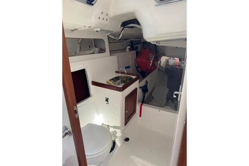 Slide: The Image of Interior of 2019 J Boats J/121 sailboat featuring compact bathroom and storage area. - 19