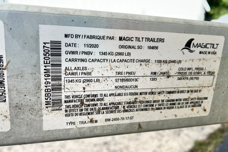 Slide: The Image of Label on Magic Tilt trailer, manufactured 11/2020, showing specifications and compliance details. - 12