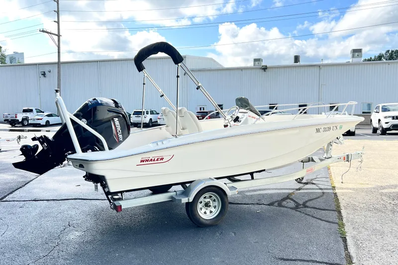 Slide: The Image of 2021 Boston Whaler 160 Super Sport boat on trailer in parking lot. - 2