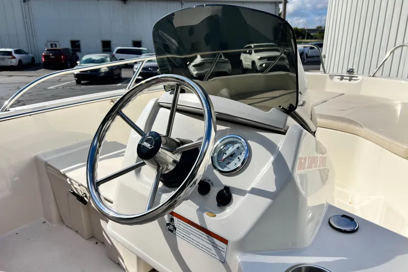 Slide: The Image of 2021 Boston Whaler 160 Super Sport boat dashboard with steering wheel and gauges. - 8