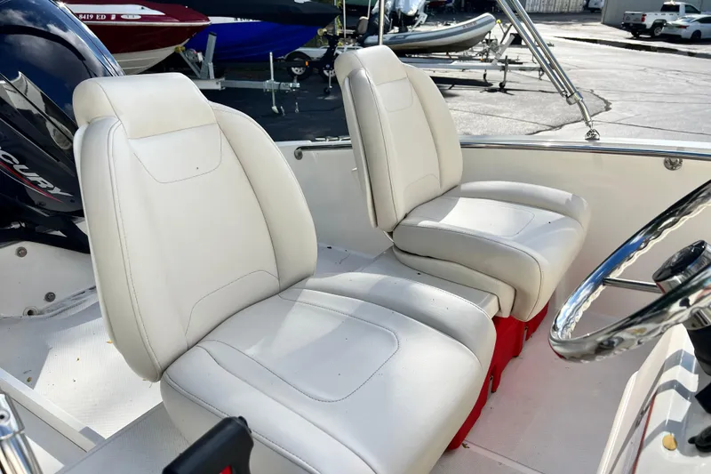 Slide: The Image of 2021 Boston Whaler 160 Super Sport boat interior with white seating and steering wheel. - 9