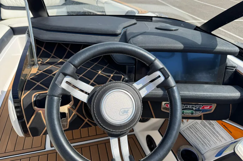 Slide: The Image of 2020 Nautique Super Air Nautique GS22 interior seating with white upholstery and cup holders. - 13