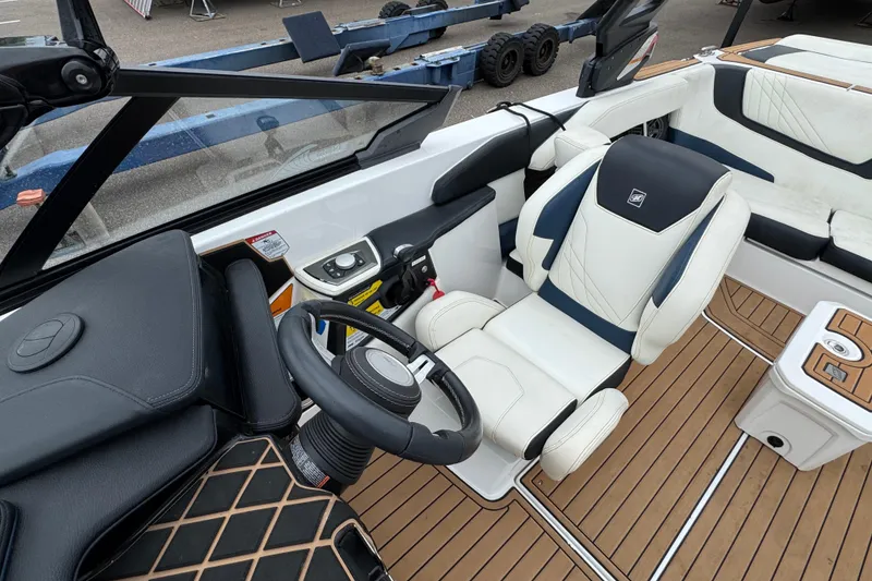Slide: The Image of 2020 Nautique Super Air Nautique GS22 boat interior with steering wheel and seating. - 19