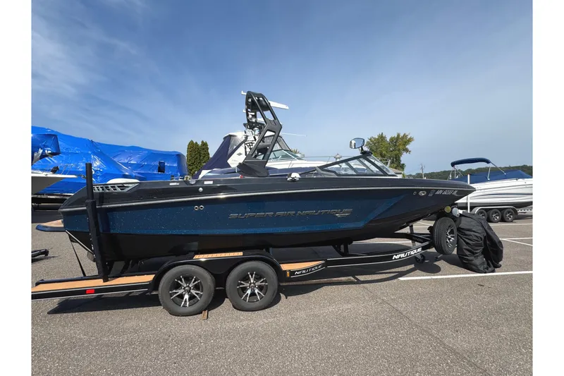 Slide: The Image of 2020 Nautique Super Air Nautique GS22 boat on trailer, covered, parked outdoors. - 2