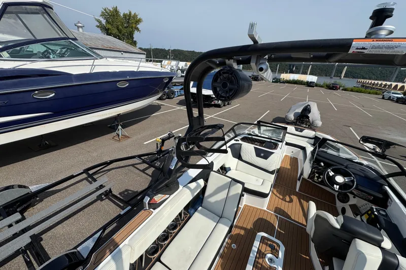 Slide: The Image of 2020 Nautique Super Air Nautique GS22 interior with blue-wrapped boats in the background. - 27