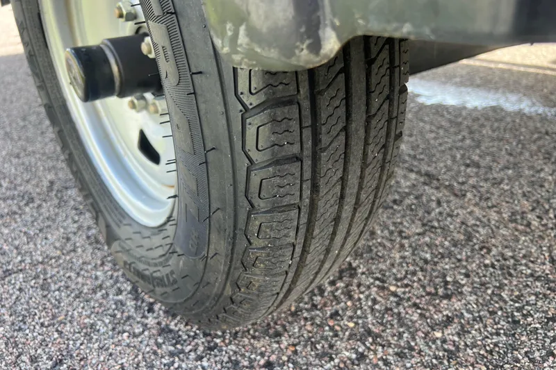 Slide: The Image of Close-up of a 2011 Alumacraft Classic 165 CS trailer tire on asphalt. - 16