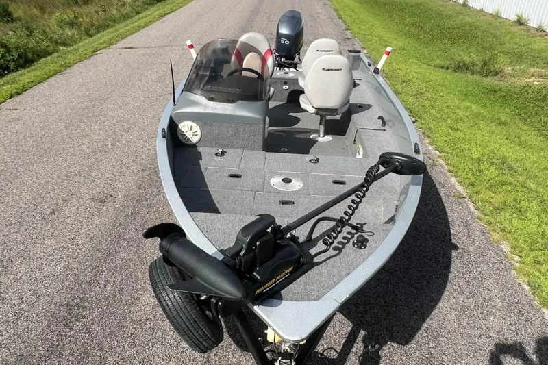 Slide: The Image of 2011 Alumacraft Classic 165 CS fishing boat on a paved road, featuring a trolling motor. - 17