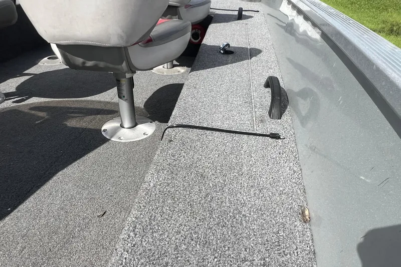 Slide: The Image of 2011 Alumacraft Classic 165 CS boat interior with gray carpet and seating. - 20