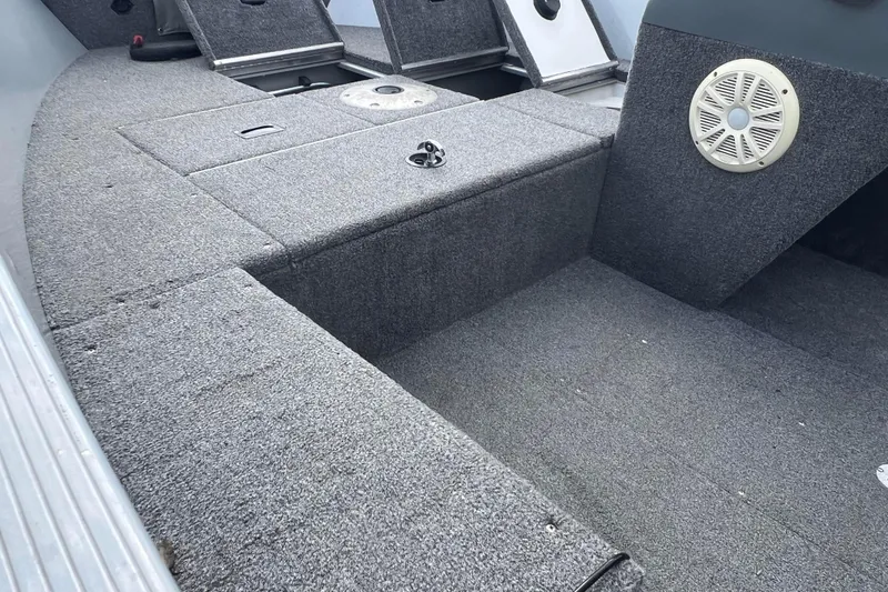 Slide: The Image of 2011 Alumacraft Classic 165 CS boat interior with carpeted deck and storage compartments. - 29