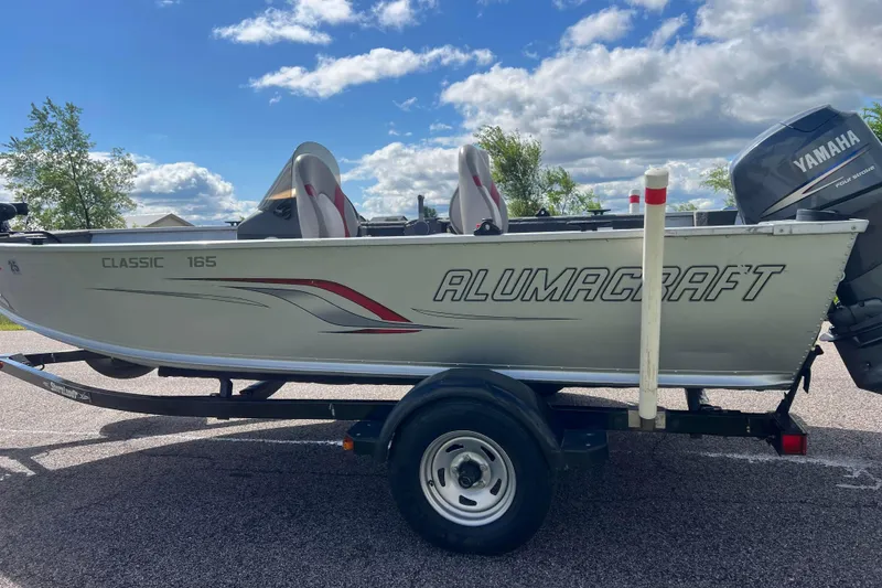 Slide: The Image of 2011 Alumacraft Classic 165 CS boat on trailer with Yamaha motor, under a blue sky. - 8