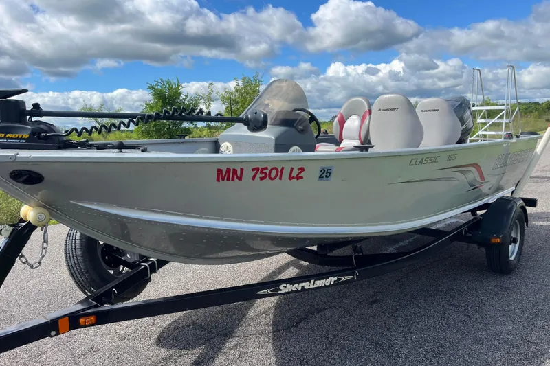 Slide: The Image of 2011 Alumacraft Classic 165 CS boat on trailer, parked outdoors under cloudy sky. - 9