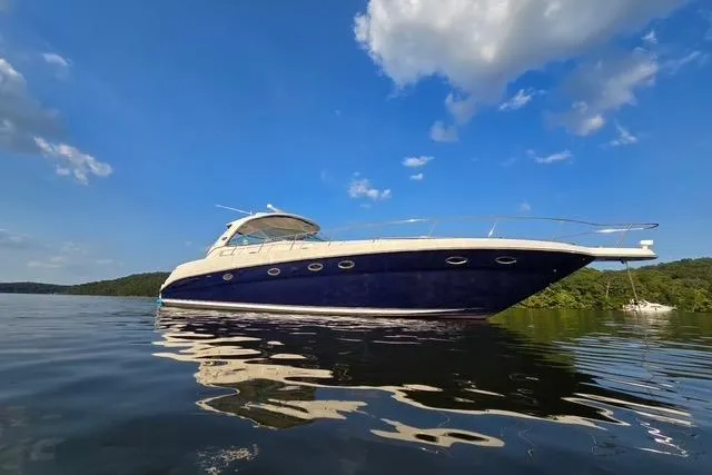 The Image of 2004 Sea Ray 460 Sundancer yacht on calm water under a clear blue sky. - 1