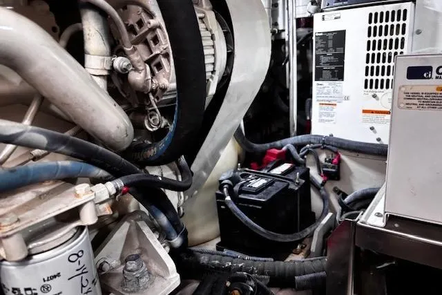 Slide: The Image of Engine room of 2004 Sea Ray 460 Sundancer, showcasing mechanical components and battery. - 44