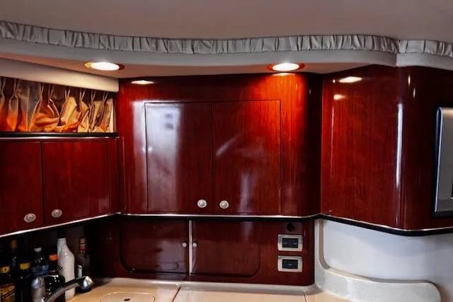 Slide: The Image of Interior of 2004 Sea Ray 460 Sundancer yacht with polished wood cabinets and modern lighting. - 49