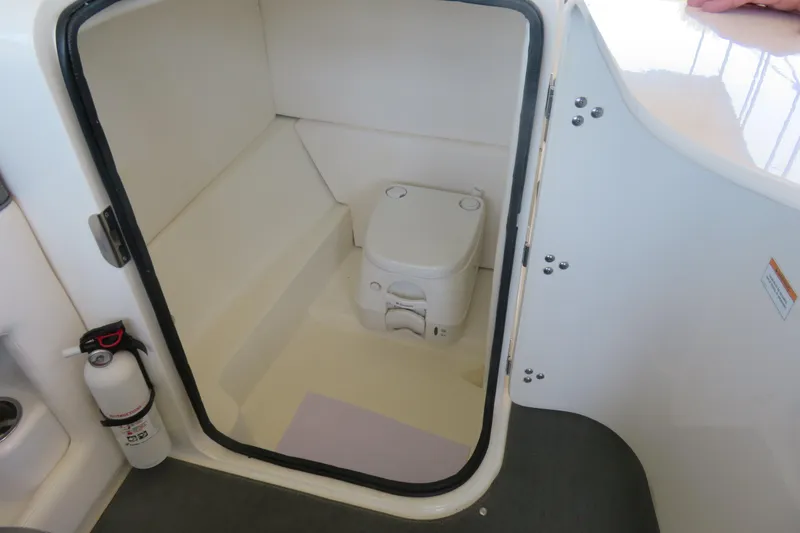 Slide: The Image of Interior of 2011 Sea Ray 240 Sundeck showing compact marine toilet and fire extinguisher. - 5