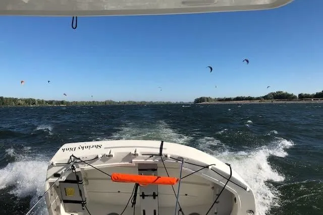 Slide: The Image of 2019 Jeanneau Velasco 37F cruising on a windy day with kite surfers in the distance. - 12