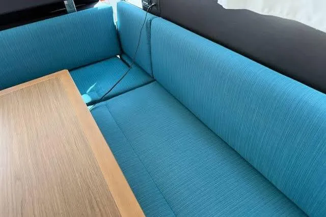 Slide: The Image of Interior seating area of a 2019 Jeanneau Velasco 37F with blue upholstery and wooden table. - 19