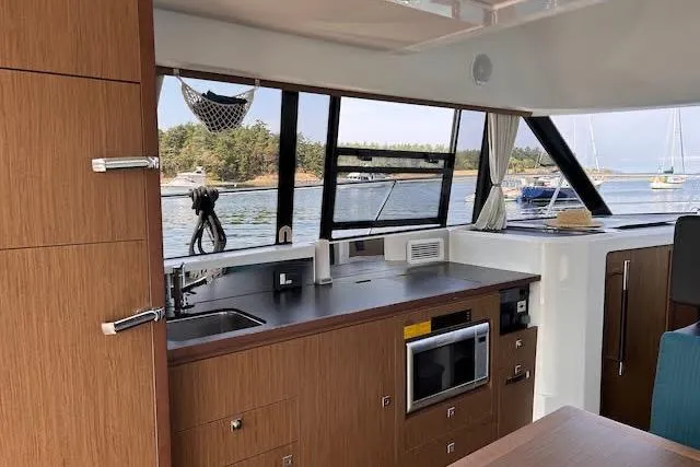 Slide: The Image of Interior of 2019 Jeanneau Velasco 37F yacht with modern kitchen and scenic window view. - 21