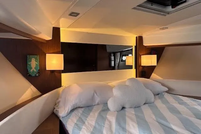 Slide: The Image of Cozy bedroom interior of 2019 Jeanneau Velasco 37F yacht with striped bedding and soft lighting. - 27