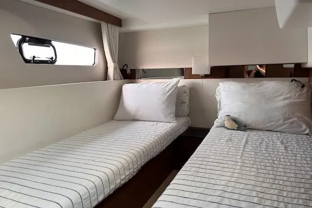 Slide: The Image of Interior cabin of 2019 Jeanneau Velasco 37F with twin beds and striped bedding. - 31