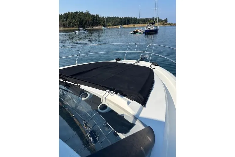 Slide: The Image of 2019 Jeanneau Velasco 37F yacht anchored in a serene bay with other boats. - 7
