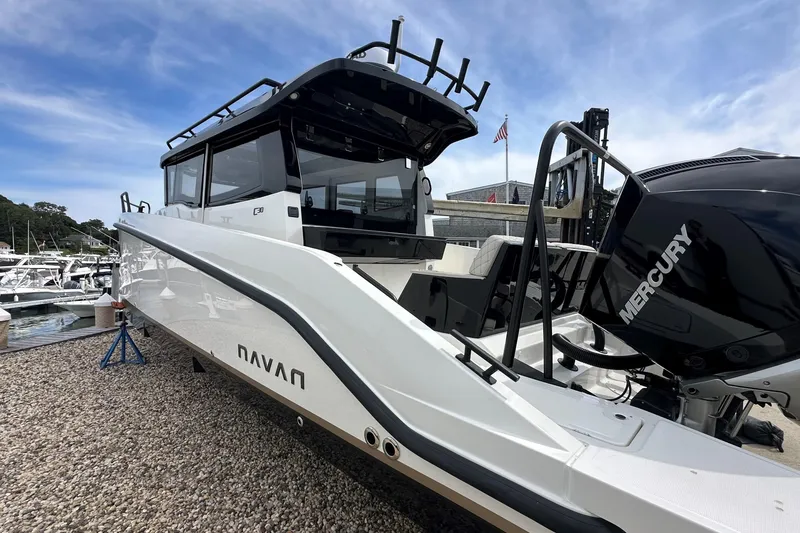 Slide: The Image of 2025 Navan C30 boat with Mercury engine, docked at a marina under a clear sky. - 3