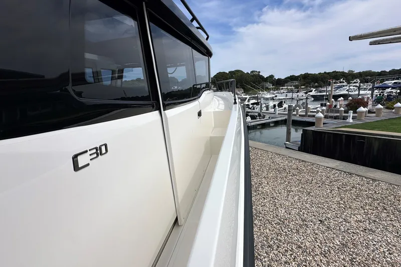 Slide: The Image of 2025 Navan C30 boat docked at a marina under a partly cloudy sky. - 53