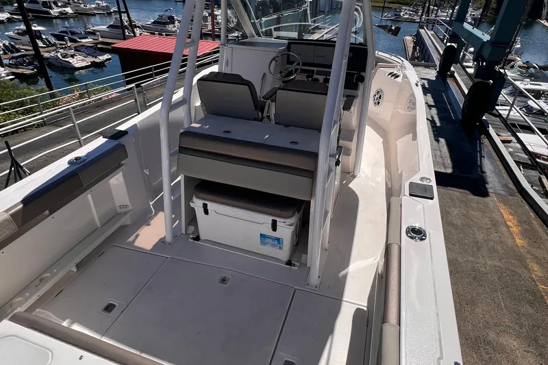 Slide: The Image of 2021 Cutwater C-24 CW boat interior with helm, seating, and marina view. - 11