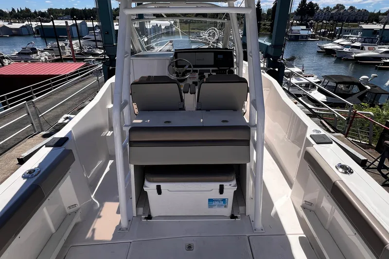 Slide: The Image of 2021 Cutwater C-24 CW boat interior with helm, seating, and cooler at marina. - 12