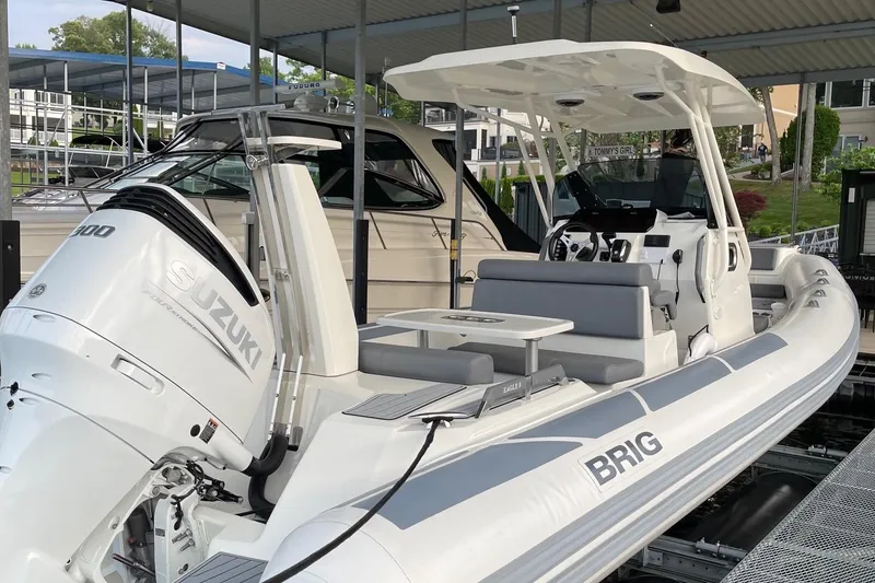 Slide: The Image of 2022 Brig Eagle 8 boat with Suzuki engine, docked under a covered marina. - 10