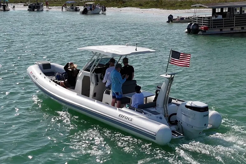 Slide: The Image of 2022 Brig Eagle 8 boat cruising on turquoise water with passengers and American flag. - 11