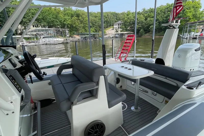 Slide: The Image of 2022 Brig Eagle 8 boat interior with seating and table, docked by a scenic lake. - 14