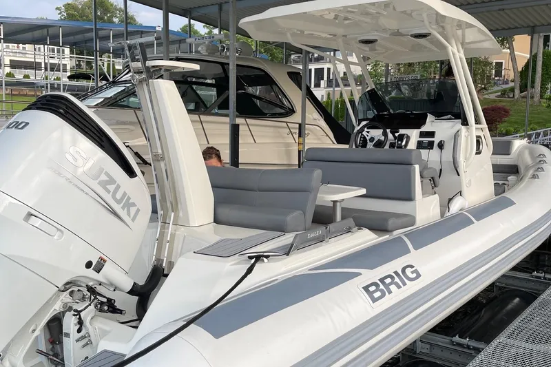 Slide: The Image of 2022 Brig Eagle 8 boat with Suzuki engine, docked under a canopy. - 3