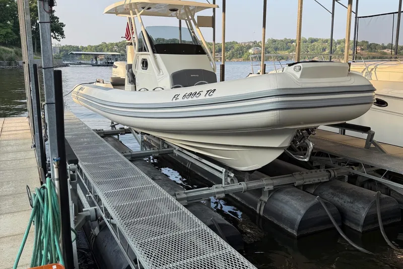 Slide: The Image of 2022 Brig Eagle 8 boat docked on a lift, with scenic waterfront background. - 6