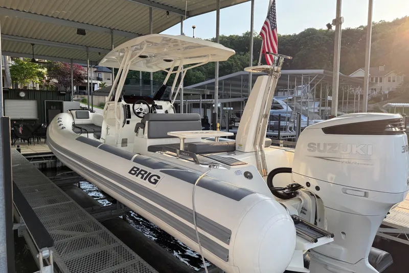 Slide: The Image of 2022 Brig Eagle 8 boat with Suzuki engine docked under a canopy. - 9