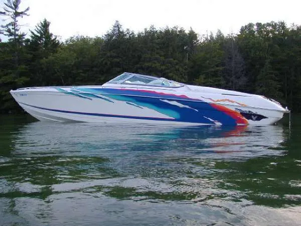 The Image of 1998 Formula 353 FASTech speedboat with colorful graphics on a calm lake. - 1