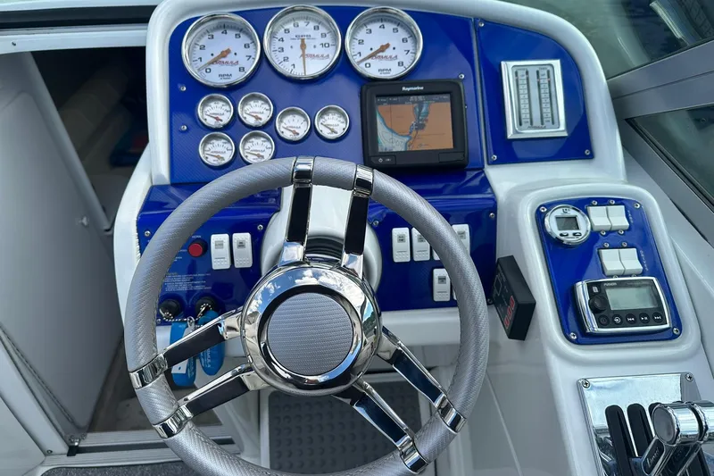 Slide: The Image of 1998 Formula 353 FASTech boat dashboard with gauges, steering wheel, and navigation system. - 14