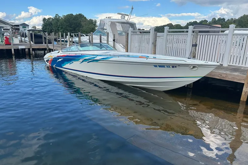 Slide: The Image of 1998 Formula 353 FASTech speedboat docked at a marina, featuring vibrant graphics. - 3
