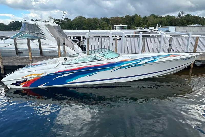 Slide: The Image of 1998 Formula 353 FASTech speedboat with colorful graphics docked at marina. - 5