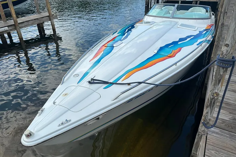 Slide: The Image of 1998 Formula 353 FASTech speedboat with colorful graphics docked on calm water. - 6