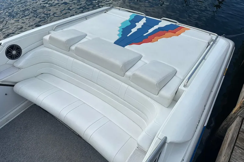 Slide: The Image of 1998 Formula 353 FASTech boat with white seating and colorful design, docked by water. - 8