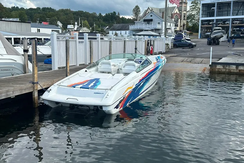 Slide: The Image of 1998 Formula 353 FASTech speedboat docked at a marina with colorful graphics. - 9