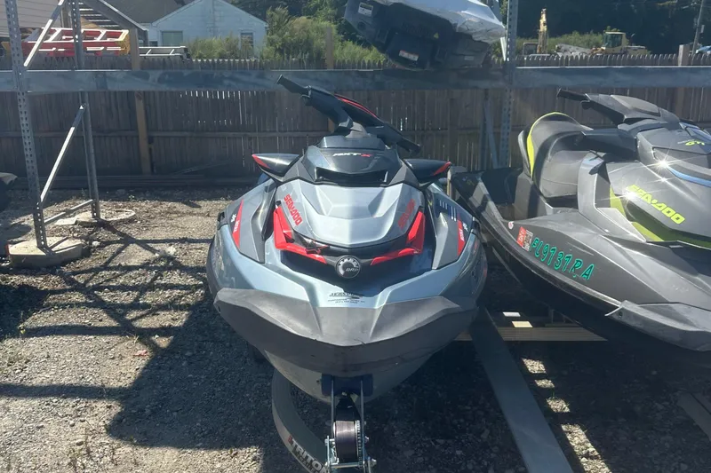 Slide: The Image of 2018 Sea-Doo RXT-X 300 jet ski parked on gravel lot. - 10