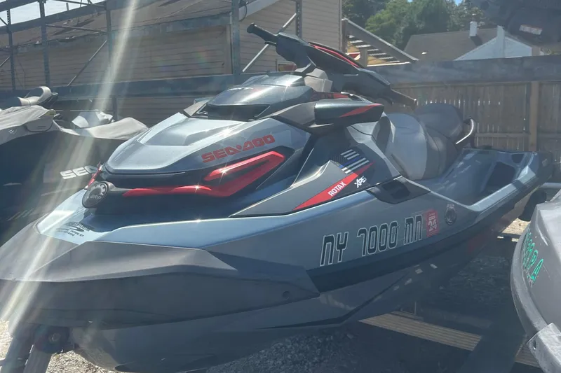 Slide: The Image of 2018 Sea-Doo RXT-X 300 jet ski in a storage area, sunlight reflecting off its surface. - 9