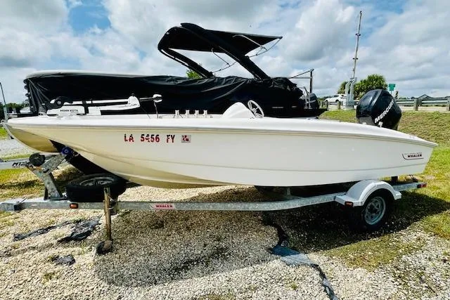 Slide: The Image of 2011 Boston Whaler 170 Super Sport boat on trailer, parked outdoors. - 12